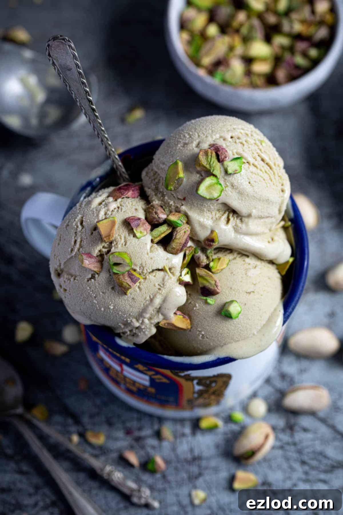 Close up of scoops of vegan pistachio ice cream in an enamel mug.