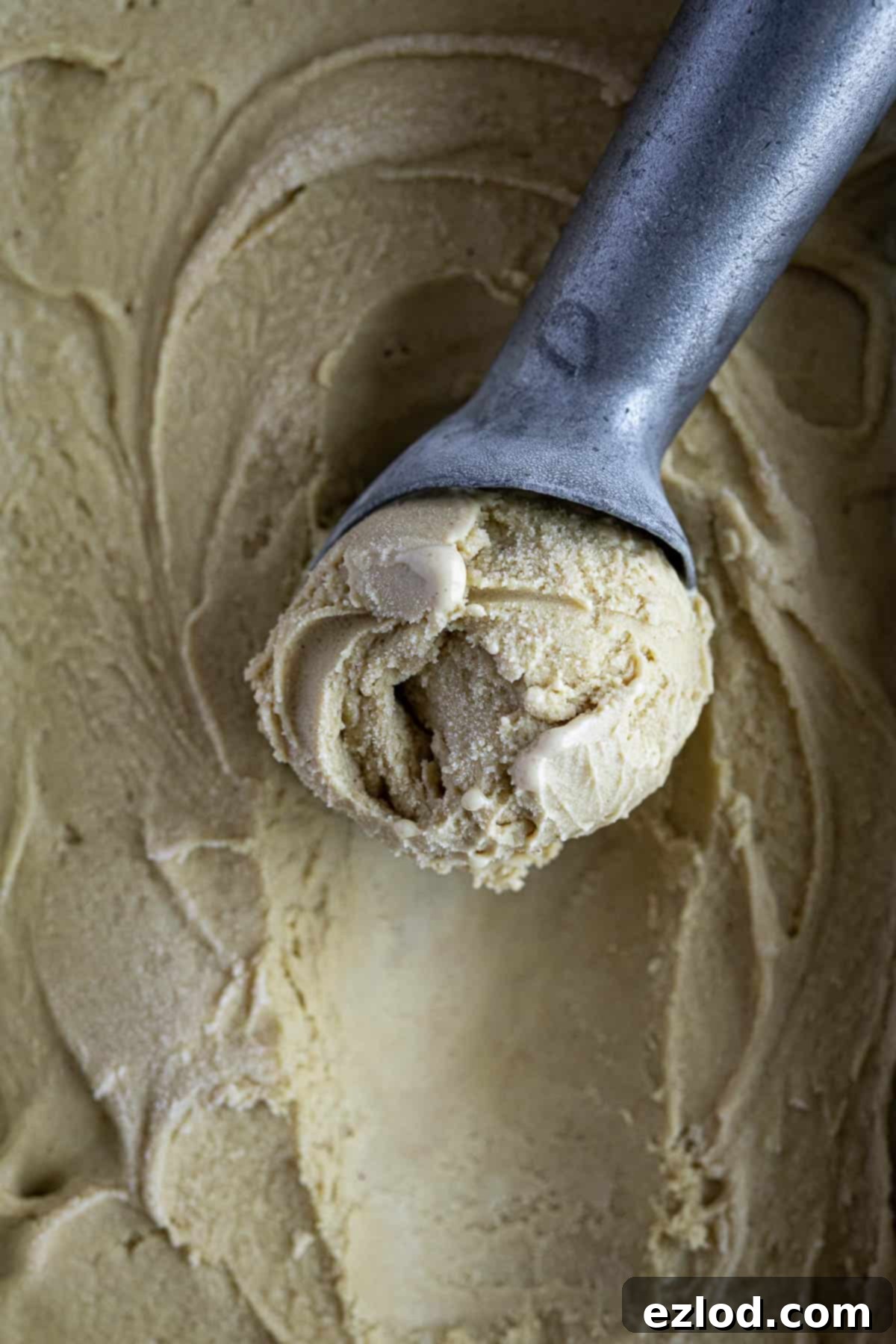 Close up of an ice cream scoop with pistachio ice cream.