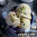 Close up of scoops of vegan pistachio ice cream in an enamel mug.