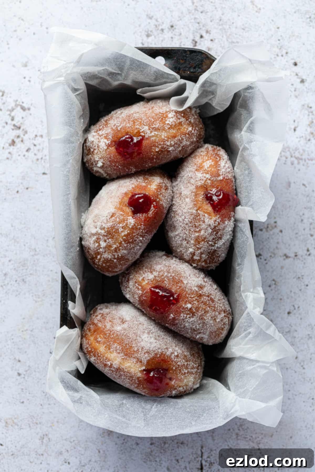 Vegan jam doughnuts in a parchment lined loaf tin.