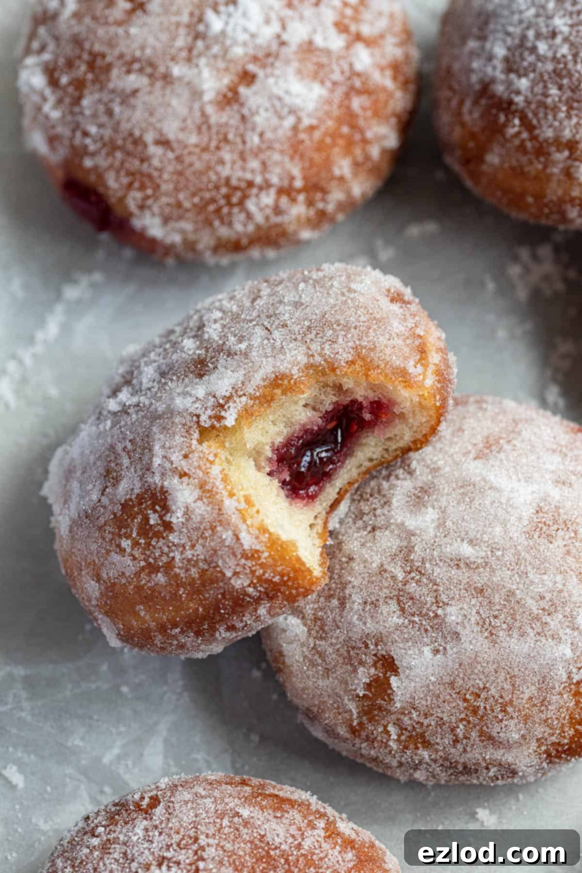 Close up of a jam doughnut with a bite taken out od it.