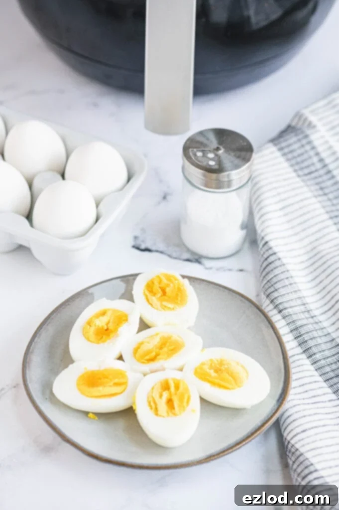 Hard boiled eggs are neatly arranged on a plate next to a salt shaker, inviting a simple seasoning.