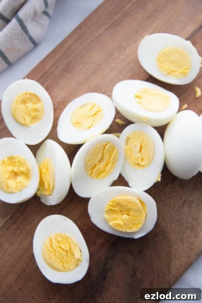 Halved Instant Pot hard boiled eggs showcasing perfectly set yolks on a rustic wooden cutting board