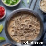Creamy Vegan Peanut Noodles 3 Creamy peanut noodles in a pan with bowls of chopped peanuts, spring onions, chillies and limes.