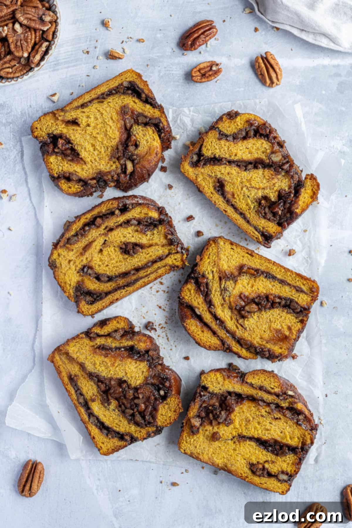 Six slices of babka on a sheet of baking parchment.