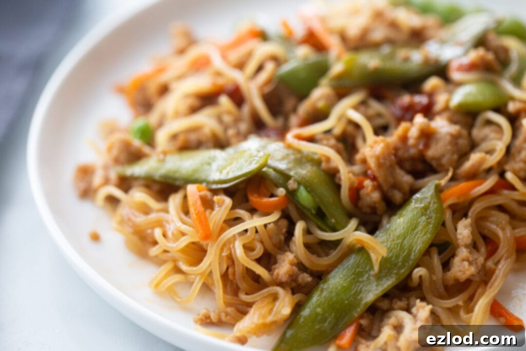 Close up photo of ramen noodles with stir fry veggies and ground chicken