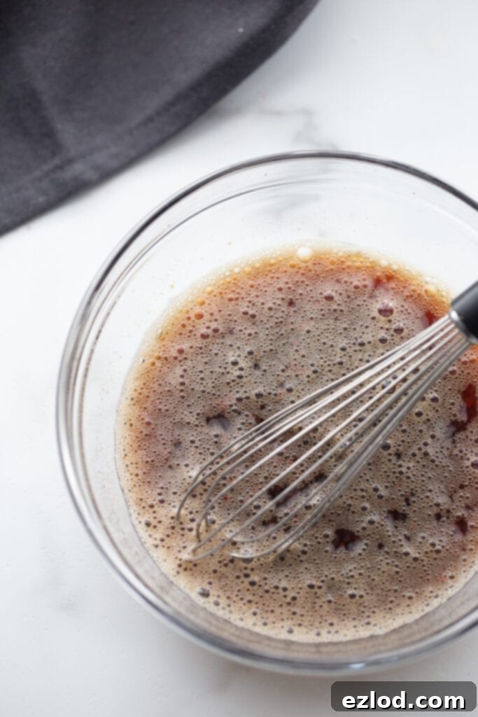 Stir fry sauce in a glass bowl with a whisk