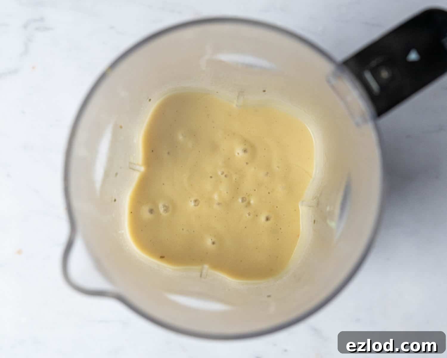 Step four: A portion of the cooked white bean soup in a blender, actively being blitzed into a smooth, creamy consistency, ready to be reintegrated with the rest of the soup.