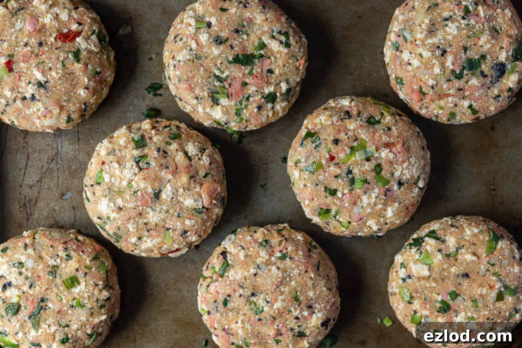 Step 7: Eight perfectly shaped vegan 'fish' cake patties arranged on a baking sheet, uniform in size and ready for cooking. Their smooth, compact form indicates they will hold together well during frying, showcasing the successful mixture consistency.