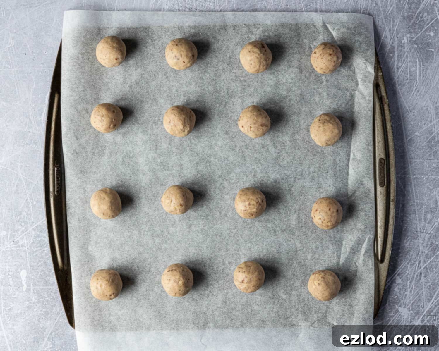 Classic Vegan Pecan Snowball Cookies 9 Step 5: Shaped vegan pecan snowball cookie dough balls neatly arranged on a parchment-lined baking sheet before chilling.