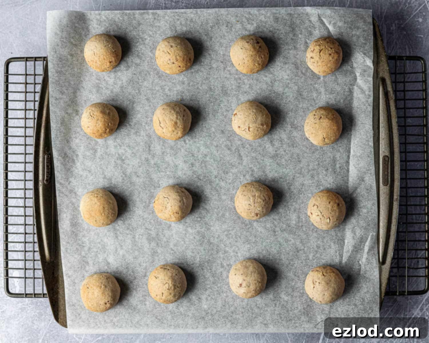 Classic Vegan Pecan Snowball Cookies 10 Step 6: Freshly baked vegan pecan snowball cookies on a baking sheet, showing a light golden brown on the bottom.