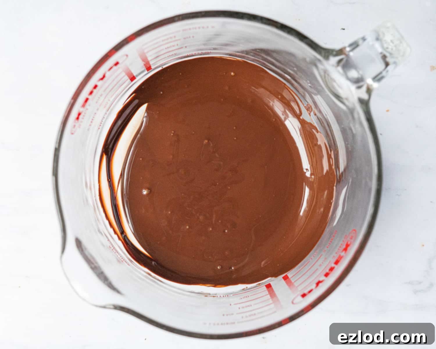 Step 1: A close-up shot of perfectly melted dark chocolate in a bowl, ready for the next step of the recipe.