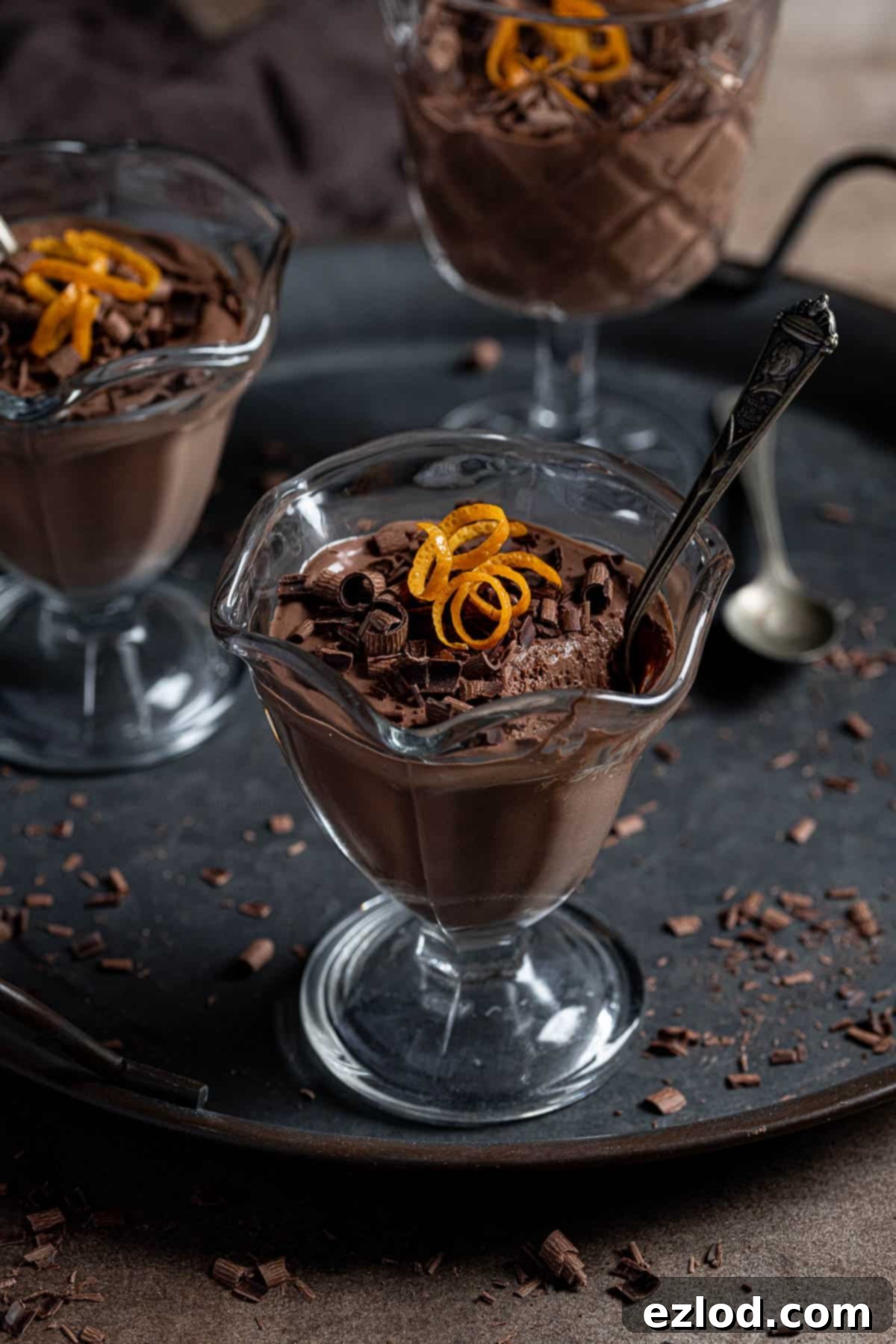 Several glasses of vegan chocolate orange mousse arranged on a serving tray, showcasing their elegant presentation.