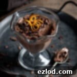 Vegan chocolate orange pot on a metal tray with a spoonful removed.