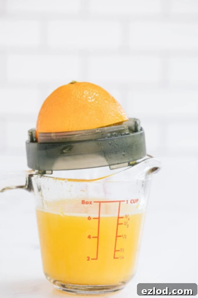 Freshly squeezed orange juice in a measuring cup, showcasing the quality ingredient for mimosas