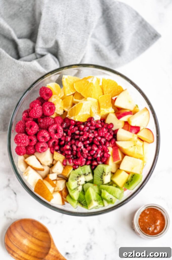 A vibrant and refreshing winter fruit salad, expertly arranged in a glass bowl, showcasing a medley of seasonal fruits. Perfect for a colorful addition to any brunch table.