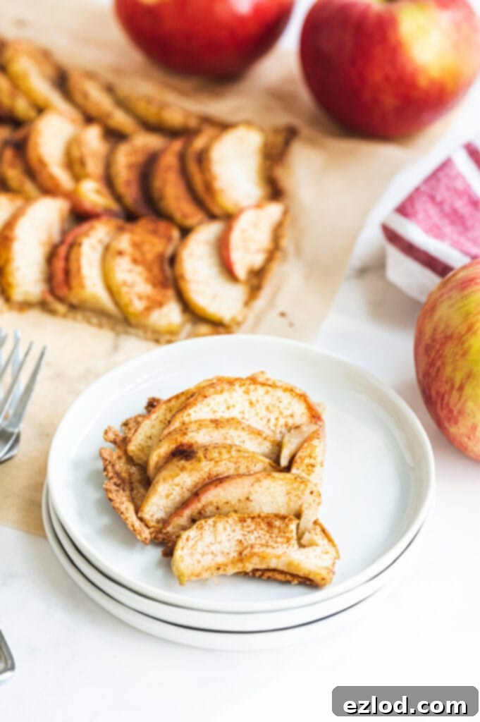 A rustic and appealing gluten-free apple tart, golden brown and artfully arranged, on a white background, perfect as a stunning centerpiece for a brunch table spread.