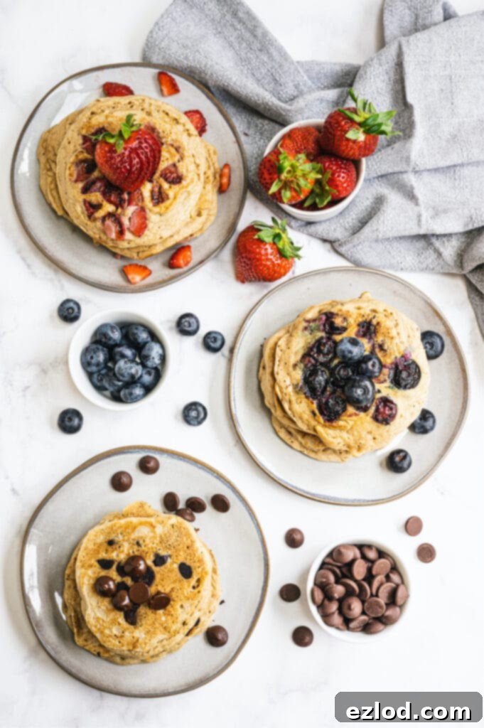 An inviting overhead photo of plates adorned with stacks of fluffy pancakes, generously topped with an assortment of fresh berries and delicious chocolate chips.