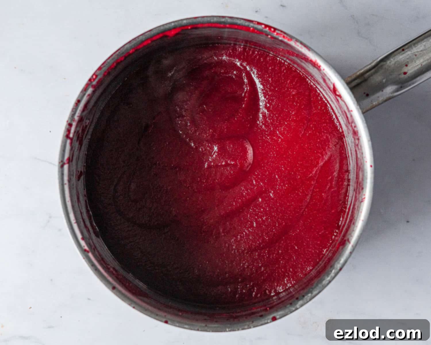 The rich, reduced raspberry puree, thickened and intensified in flavor after simmering, ready for the white chocolate mousse.