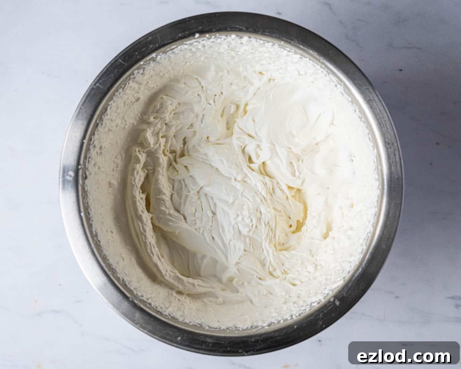 Soft peaks formed by whipped vegan cream, perfectly airy and ready to be folded into the raspberry white chocolate mixture.