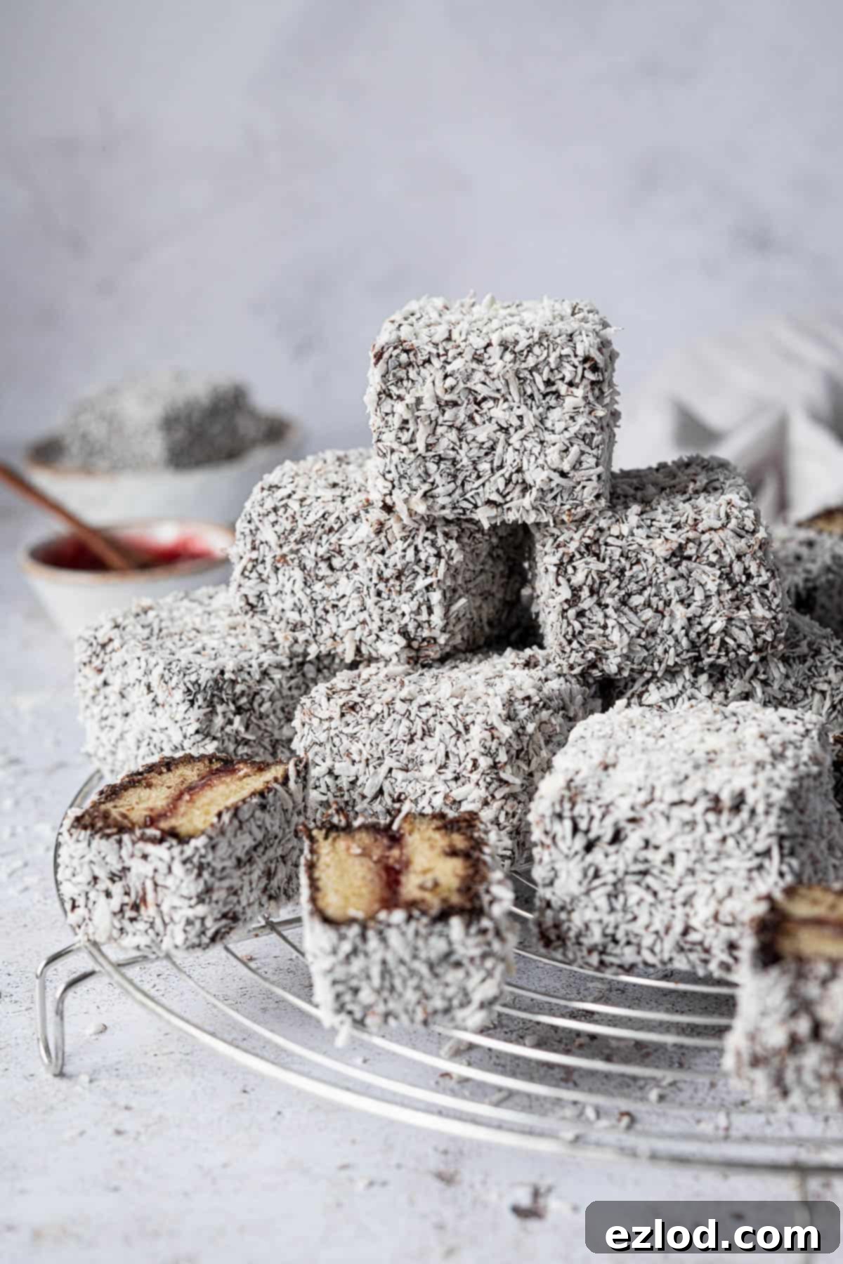 A stack of vegan Lamingtons on a round wire rack.