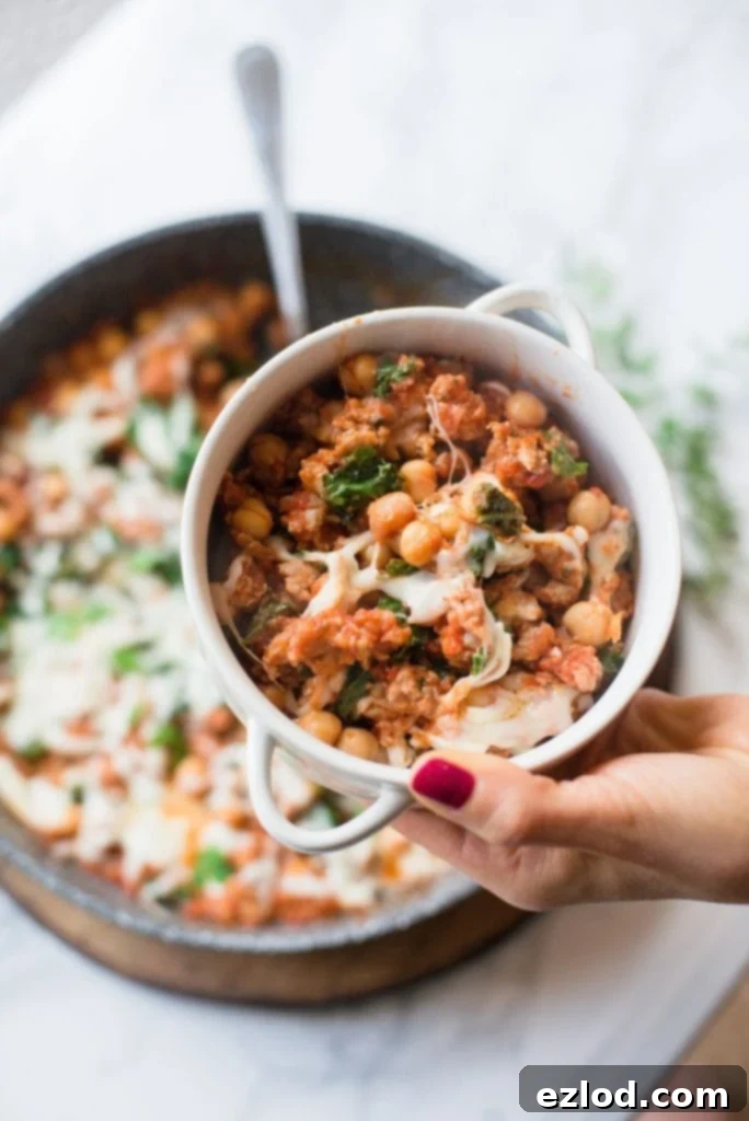 A small portion of Healthy Sausage, Bean, and Kale Skillet prepared for the 21 Day Fix, served in a rustic crock, showing its hearty and wholesome ingredients.