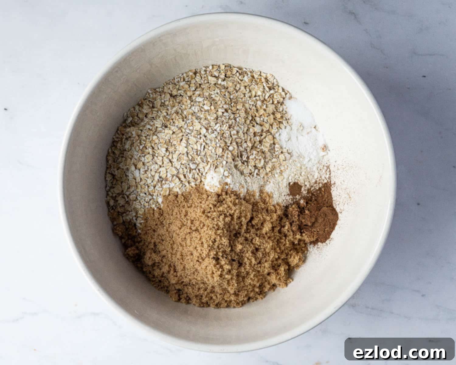 Vegan Mincemeat Crumb Bars 4 Step 1 in making mincemeat crumble bars: a large bowl containing all the dry ingredients mixed together, ready for the butter.