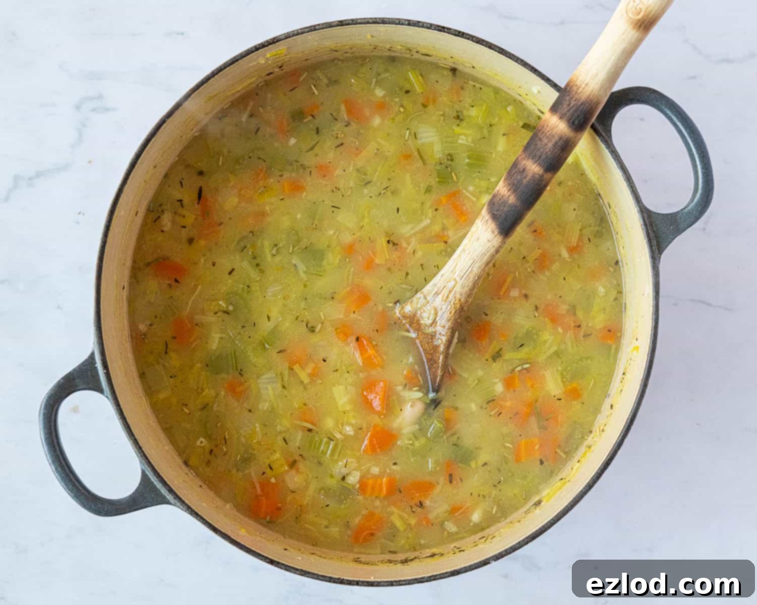 All the soup ingredients including rice, beans, and herbs, combined in a pot before simmering.