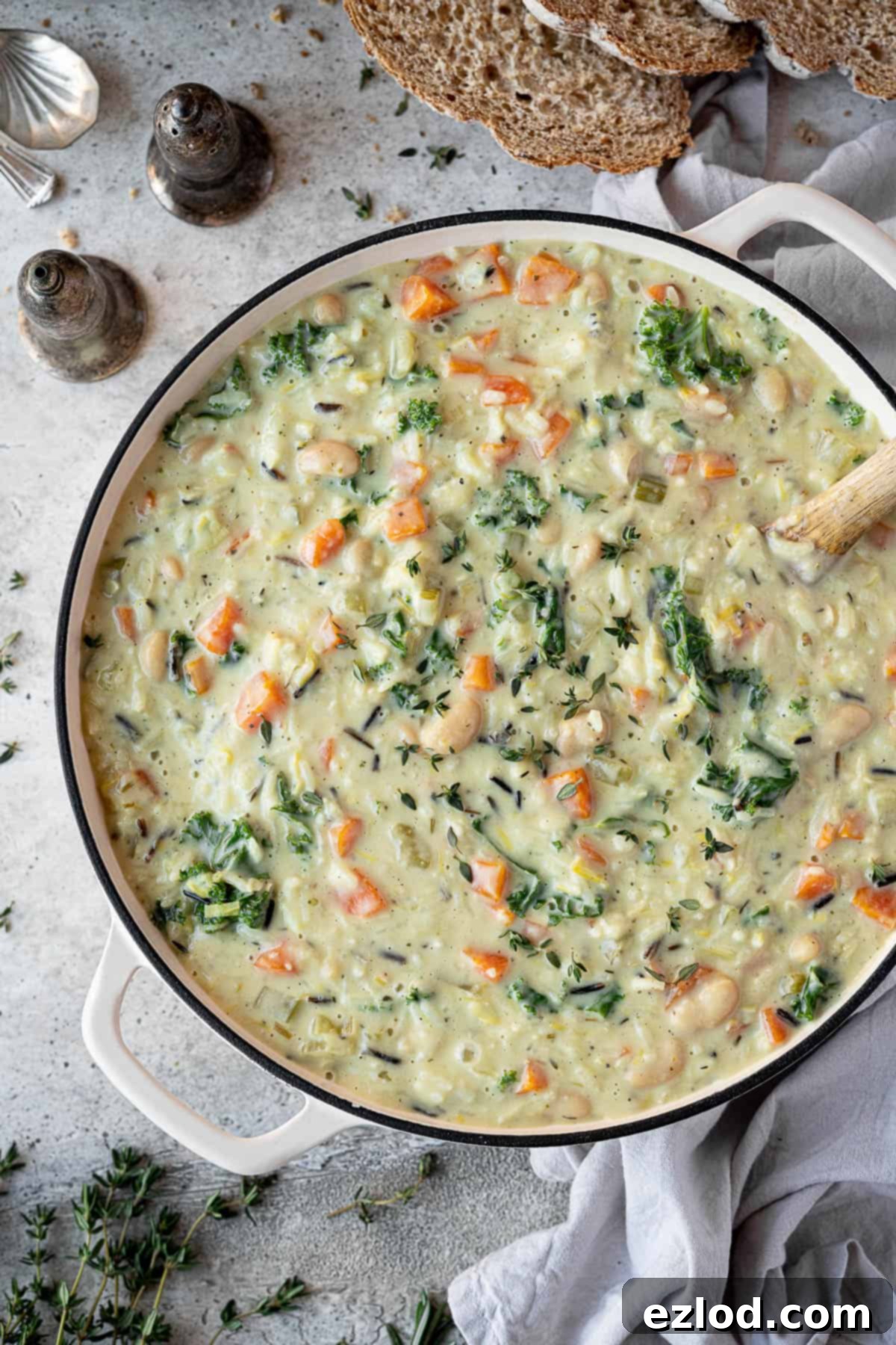 Close up view of the finished creamy vegetable rice soup simmering gently in a pot, ready to be served.