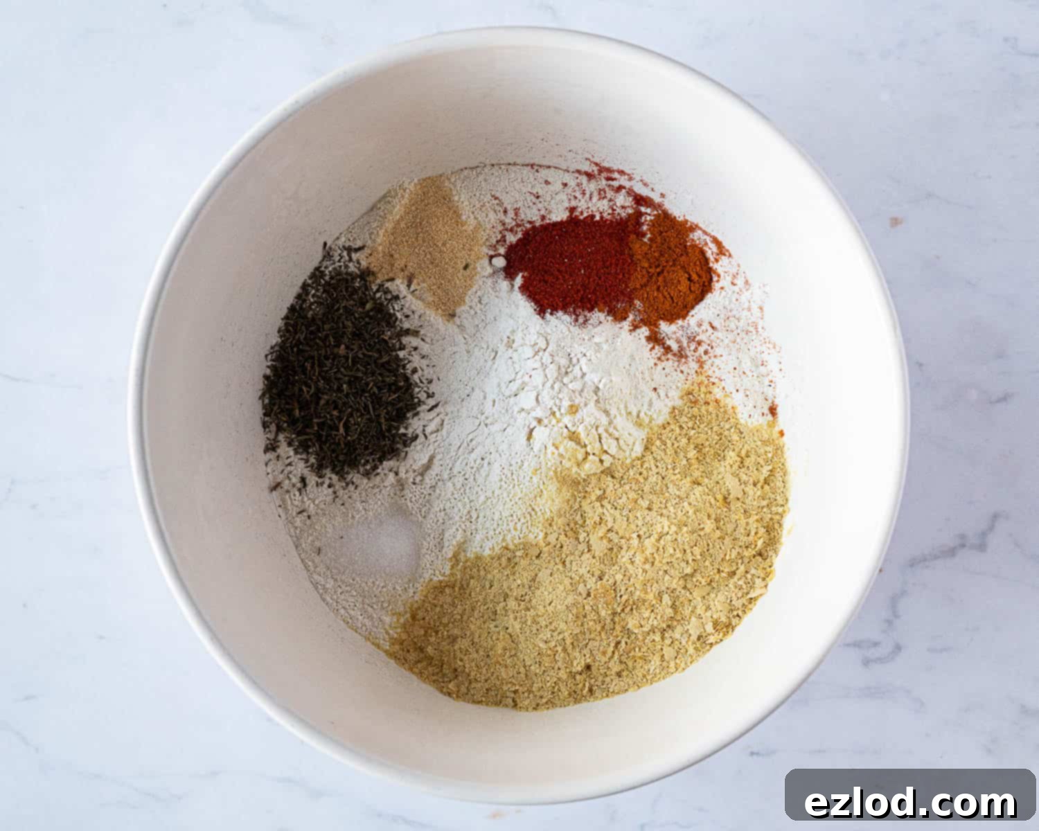 Step 1: All dry ingredients for the savoury vegan scones, including flour, baking powder, nutritional yeast, and spices, mixed together in a bowl.