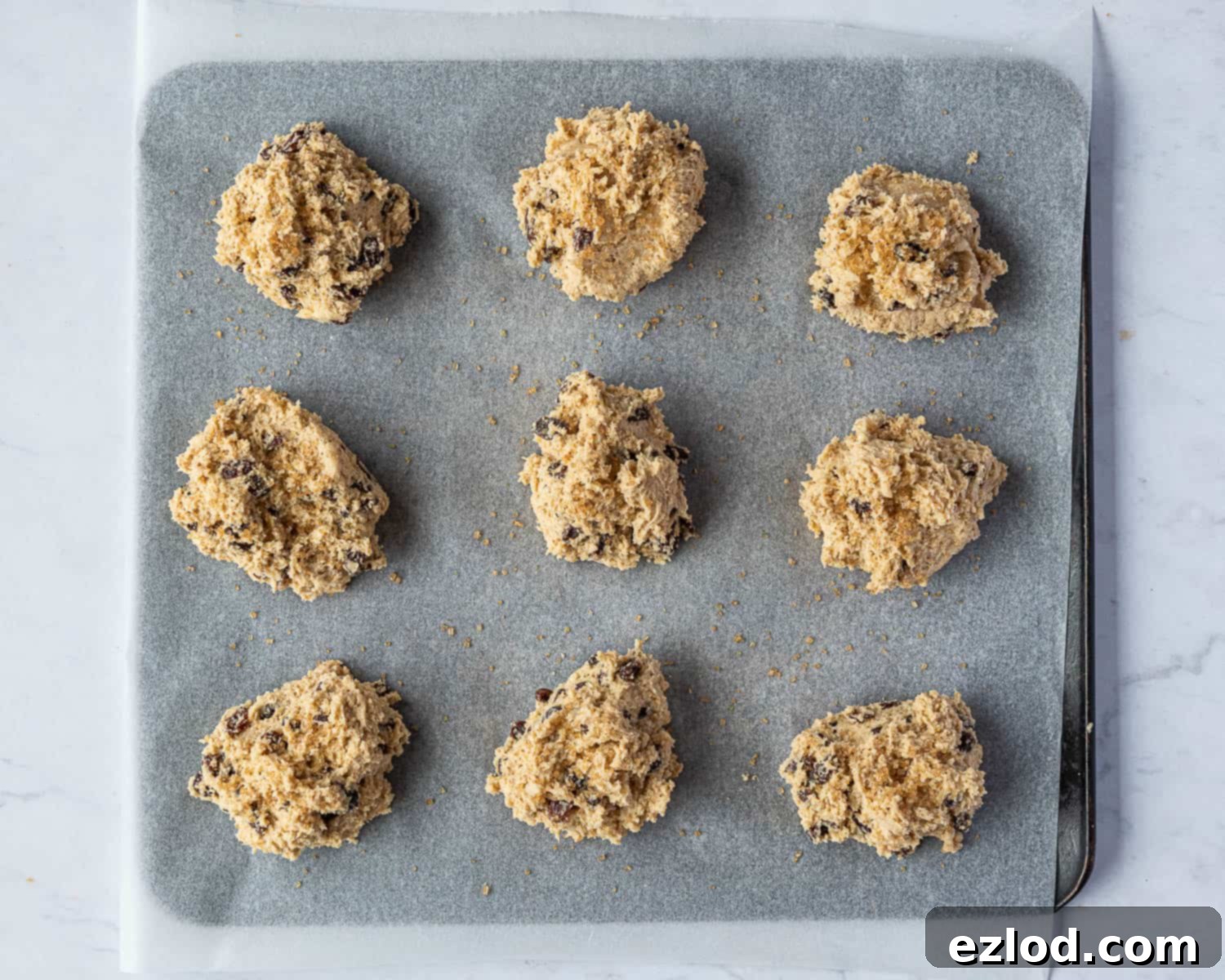 Step 4 in making vegan rock cakes: Dollops of rustic dough are spooned onto a lined baking sheet, spaced apart before baking.