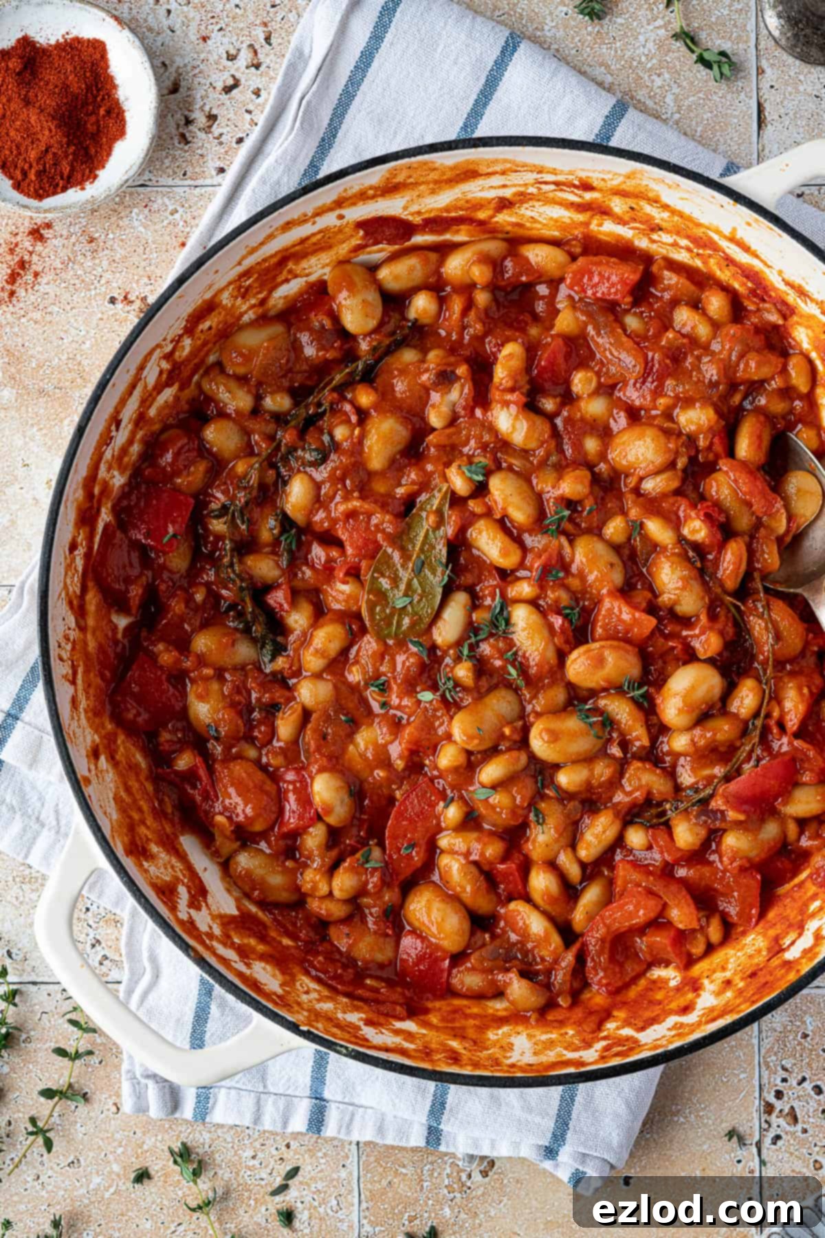 Hearty Smoky Tomato Beans 4 Close-up shot of the smoky tomato beans simmering gently in a white pan, showcasing the rich sauce and tender beans.