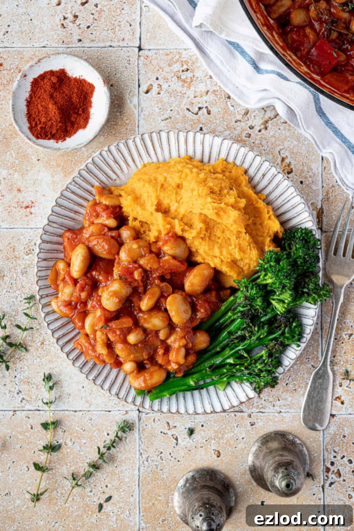 Hearty Smoky Tomato Beans 5 A beautifully arranged plate showcasing a hearty portion of smoky tomato beans, creamy sweet potato mash, and fresh steamed broccoli, ready to be enjoyed.