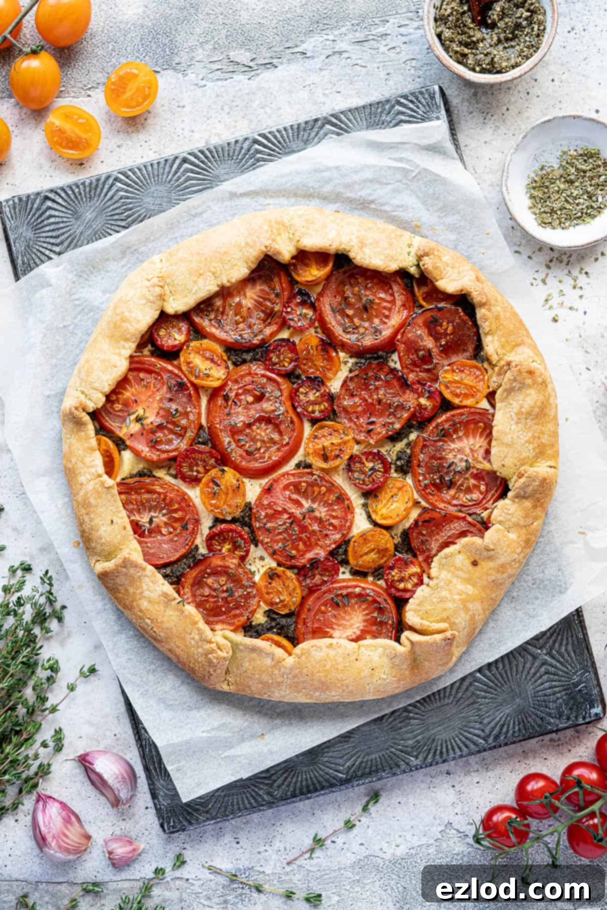 The freshly baked vegan tomato ricotta galette, golden brown and crisp, resting on a sheet of baking parchment.