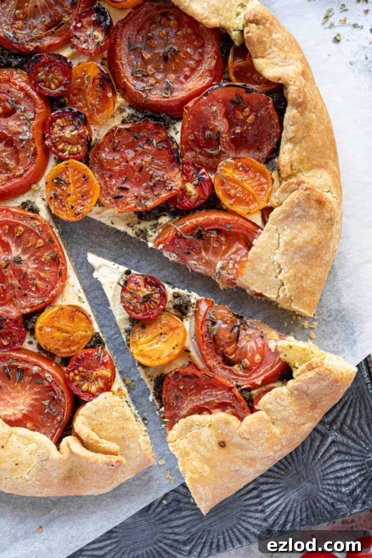 Close-up of a perfectly baked slice of vegan tomato ricotta galette, showing the distinct layers of crisp crust, creamy almond cheese, and colorful tomatoes.