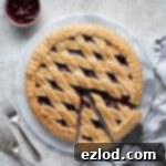 Close-up of a golden-brown vegan jam crostata with a perfect lattice top, ready to be sliced and served.