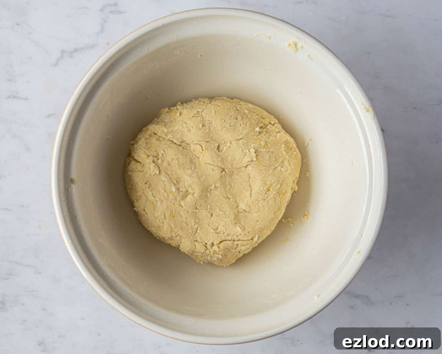 The prepared vegan pastry dough for crostata, shaped into a smooth disc and tightly wrapped, ready for its essential chilling period in the refrigerator.