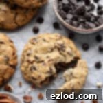 Close up of a chunky chocolate pecan cookie broken in half.