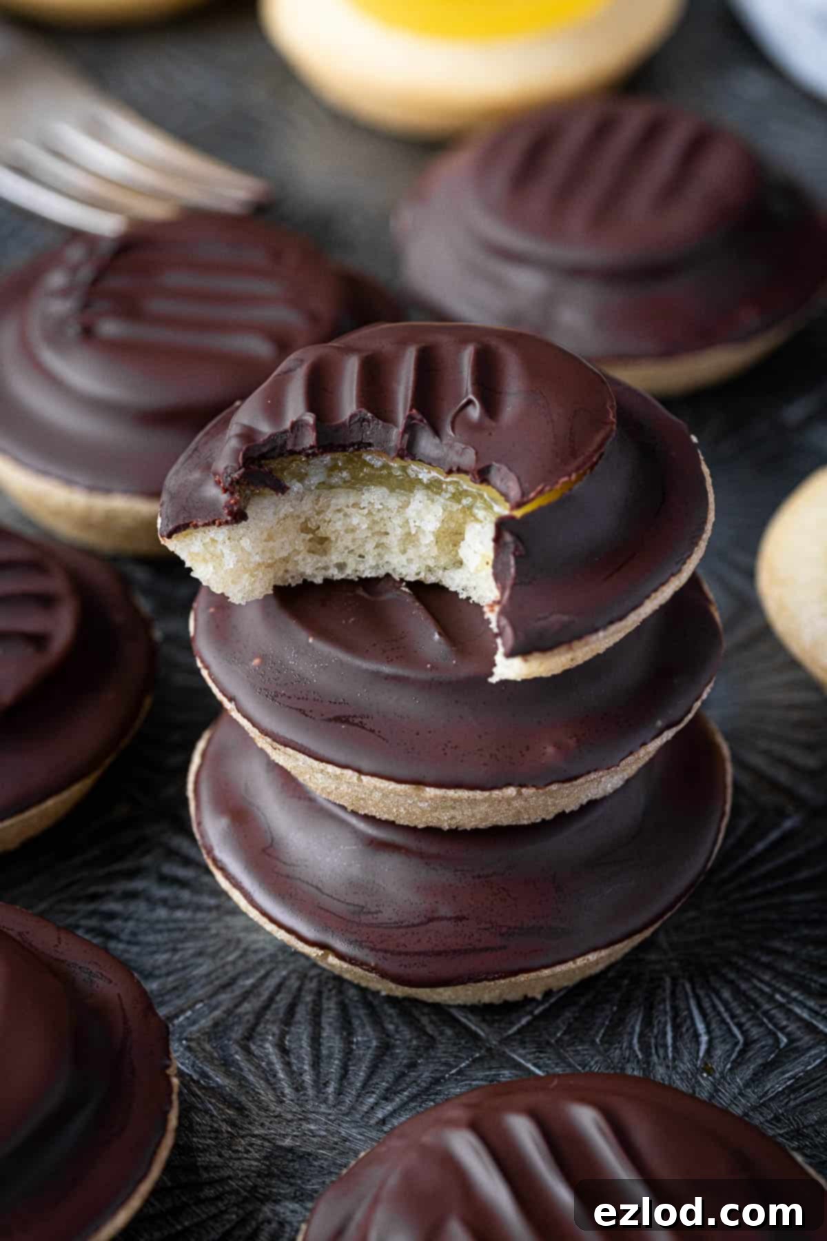 A stack of vegan jaffa cakes, one with a bite taken out of it.