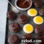 Vegan jaffa cakes on a metal tray with a bowl of chocolate.