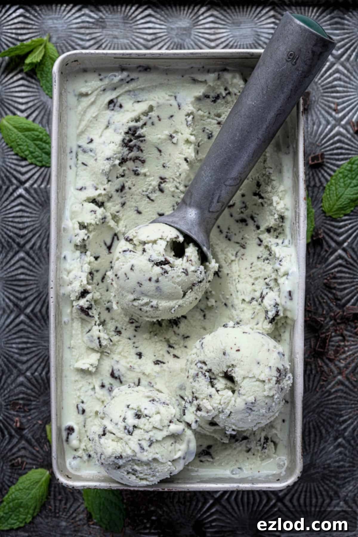 Mint choc chip ice cream in a loaf tin on a baking tray.
