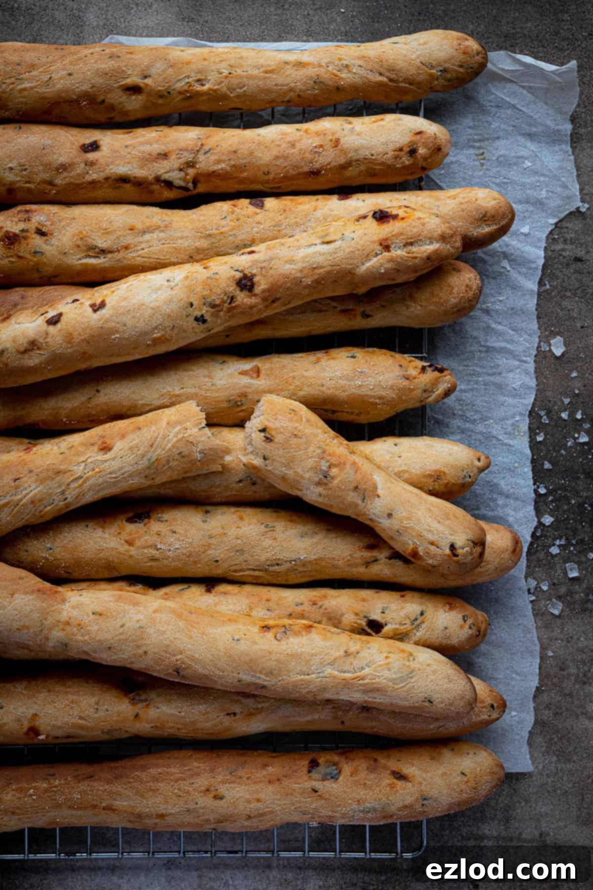 Artisan Sun Dried Tomato Breadsticks 9 Sun dried tomato breadsticks on a wire rack.