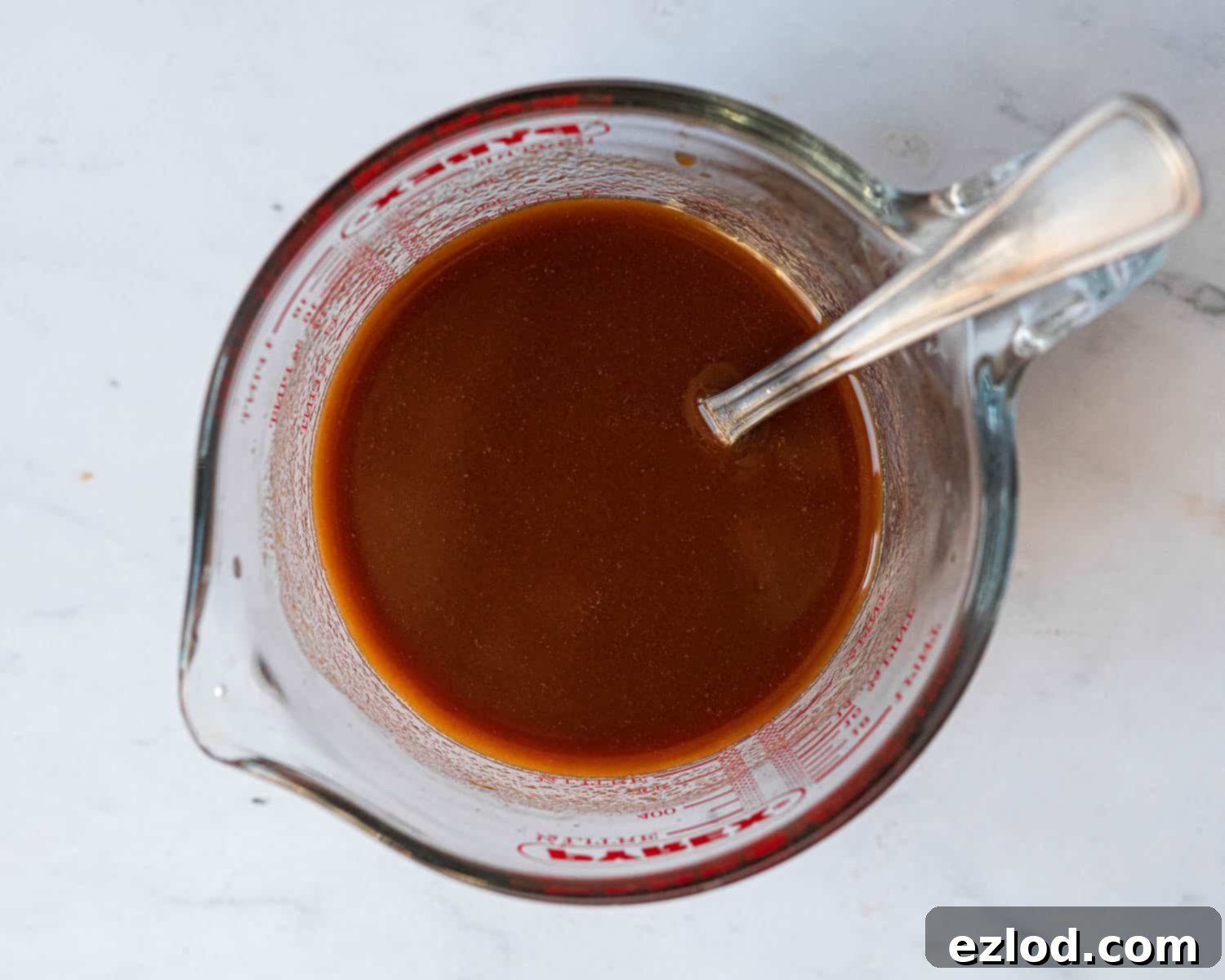 Step 1: The sweet and sour sauce ingredients, including pineapple juice, brown sugar, and soy sauce, whisked together in a measuring jug.