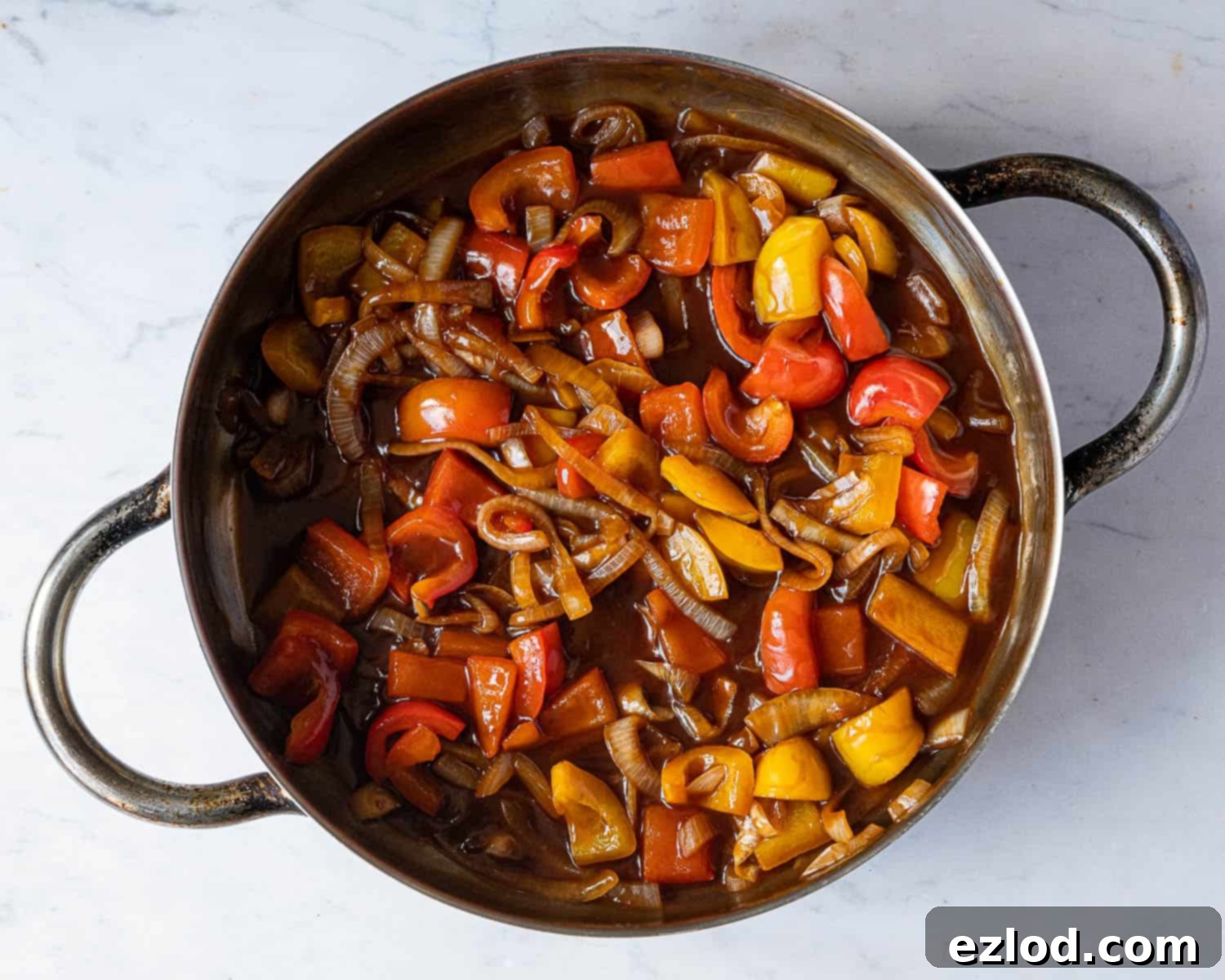 Step 5: The sweet and sour sauce thickening in a pan, achieving a glossy, rich consistency as it simmers.