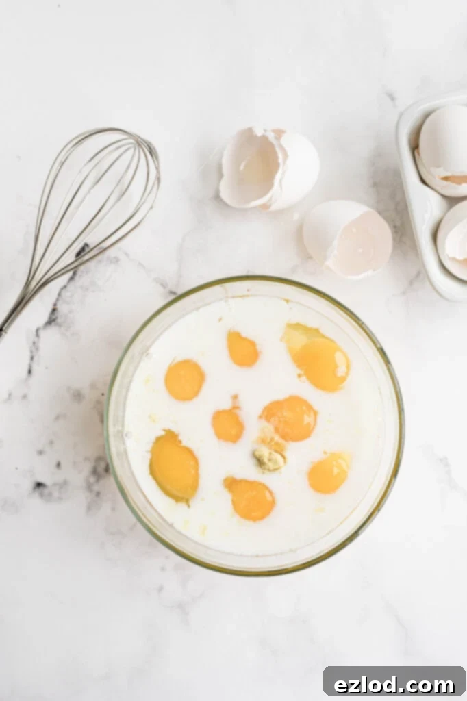 A bowl of whisked eggs and almond milk, ready for the casserole