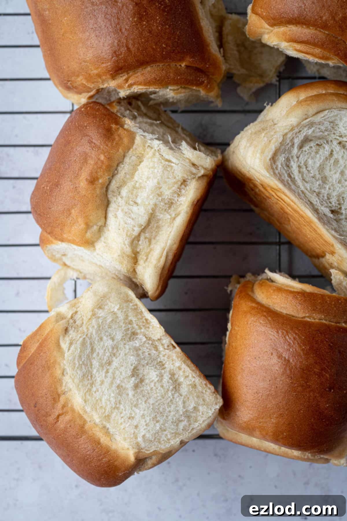 Milk bread rolls on a wire cooling rack.
