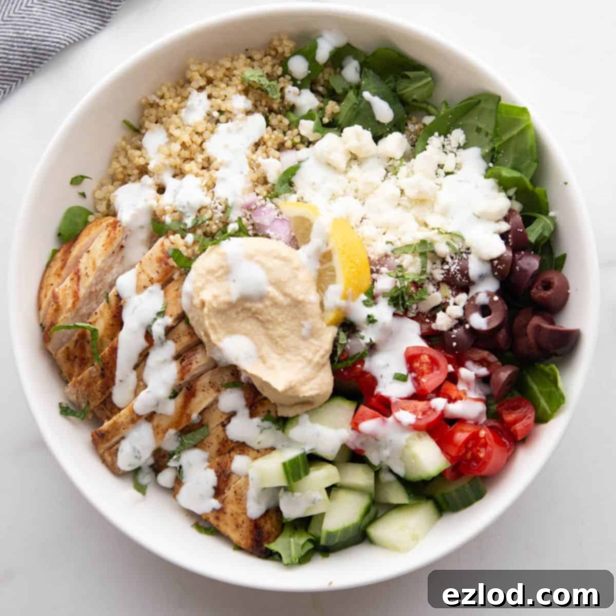 Mediterranean Bowl with chicken, hummus, veggies, and tzatziki dressing.