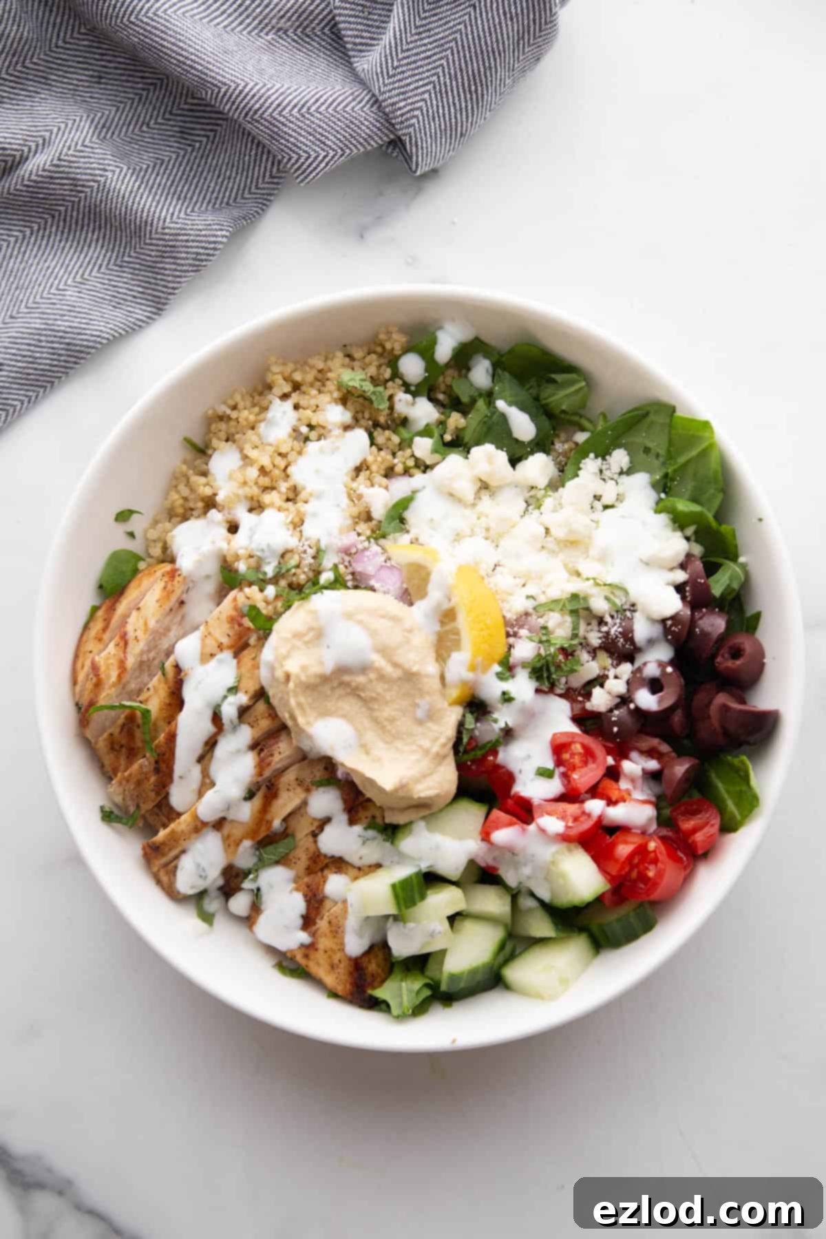 Mediterranean Bowl with chicken, hummus, veggies, and tzatziki dressing.