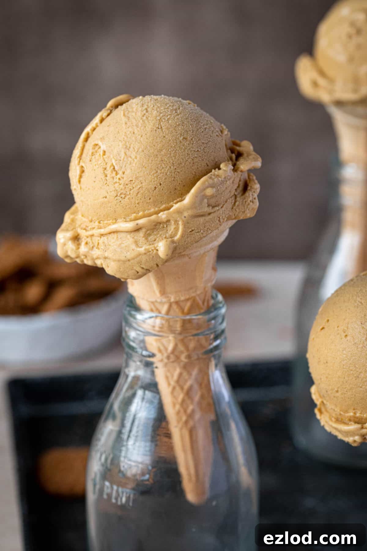 Close up of a scoop of pumpkin ice cream in a cone.