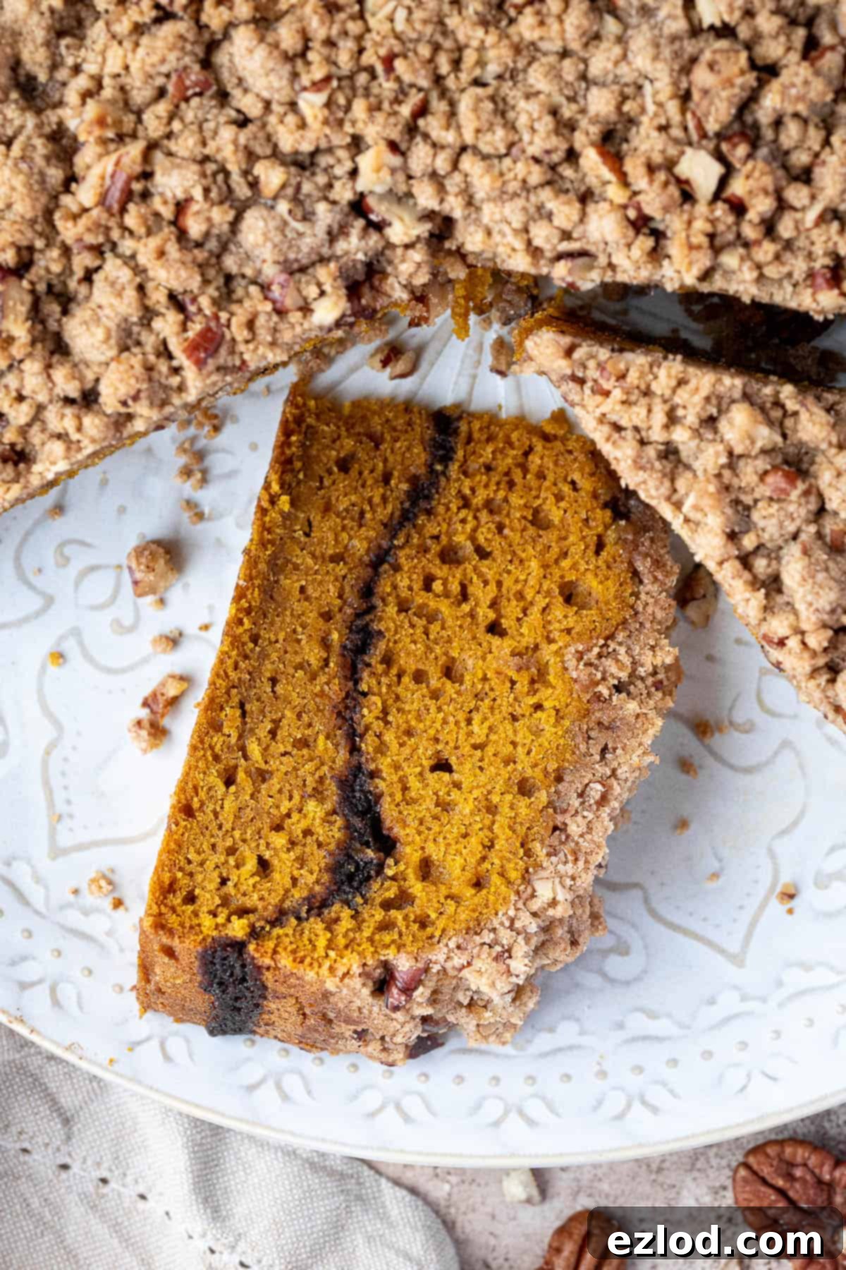 Close up view of a perfect slice of vegan pumpkin coffee cake, showing the crisp streusel and the cinnamon sugar swirl.